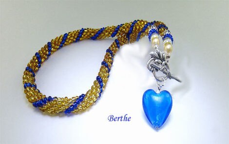 Collier de perles Berthe une sélection de perles de haute qualité et délicate, Couleur : or et bleu. Ce collier est terminé par des embouts de métal argent et deux perles shambella et un fermoir à bascule qui est très décoratif et aussi pour les personnes qui ont des douleurs aux mains. Grandeur 52 cm, avec un coeur en verre bleu. www.metiersdart-cadeaux.com