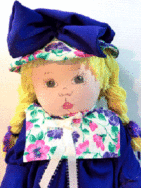 Poupée de chiffon Anne-Delphine Poupée de chiffon mauve, son chapeau est mauve avec une grosse boucle et le contour du chapeau est fleuri la meme chose que le collet de la robe. La robe est aussi mauve avec un collet fleuri. Ses cheveux sont en laine jaune. Son visage est peint elle poss`de des yeux bruns Je dois être nettoyée avec une éponge ou une brosse douce et sèche. Ne me lavez jamais! Mes vêtements sont lavables. J’ai aussi une bouche en cœur, pour vous donner des bisous. De la hauteur de mes 45cm (18″) je peux être à p.s. j’ai mon ourson avec moi. www.metiersdart-cadeaux.com