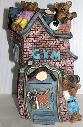 La tirelire en forme de GYM avec des petites briques rose et la porte bleu et la porte est bleu, il y a des petits oursons sur le toit et un autre a la porte vient avec son cadenas et sa clé. Elle mesure26 cm X 13.5 cm ou 10″ X 5″. www.metiersdart-cadeaux.com