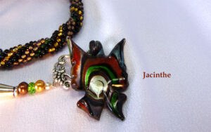 Collier de perles Jacinthe. Un collier de perles de verre qui va correspondre à faire un effet que vous souhaitez laisser paraître. Parce que la perle donne incontestablement un style chic. Le collier de perles Jacinthe est composé de perles noires avec insertion de perles or et brune. Le fermoir est idéal pour les personnes qui ont des douleurs aux mains. Il mesure 55 cm incluant le fermoir. Le pendentif mesure 5 cm