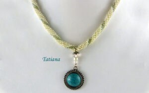 Collier de perles Tatiana, Collier de perles Tatiana. Ce dernier est composé de perles blanches avec insertion de perles verte,Il mesure 52 centimètres et son pendentif est de 4 centimètres.La terminaison de ce collier est terminée avec les perles blanches et vertes. Il possède un fermoir a bascule argent et est aussi très décoratif.