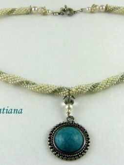 Collier de perles Tatiana. Collier de perles Tatiana. Ce dernier est composé de perles blanches avec insertion de perles verte,Il mesure 52 centimètres et son pendentif est de 4 centimètres.La terminaison de ce collier est terminée avec les perles blanches et vertes. Il possède un fermoir a bascule argent et est aussi très décoratif.