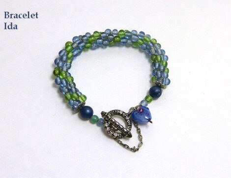 Bracelet de perles de verre bleues avec insertion de perles vert fermoir facile pour attacher le bracelet avec une chaine de sécurité et un petit coeur bleu en verre.