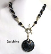 Ce magnifique collier est composé de perles de verre noires avec insertion de perles argent et parsemé de perles or il est a relief les perles noires sont surélevées, il y a un pendentif rond noir avec des flocons de coleur argent et or. Il se termine avec un fermoir décoratif qui est facile à attacher