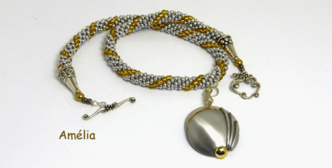 Collier de perles fait à la main avec des perles argenté et insertion de perles or. Dans le centre il y a un pendentif en aluminium vantage fait aussi a la main. Le tout est terminé avec un fermoir décoratif et facile à attacher. Ce collier est une pièce unique