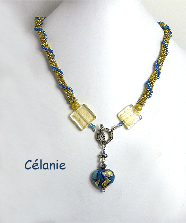 Collier crocheté de perles or avec insertion de perles bleues surélevées, terminées par une perle de forme carrée de murano terminé avec un joli coeur décoratif qui possède les mêmes couleurs que le collier et le fermoir est argent décoratif et facile a attacher.