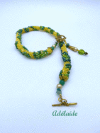 Collier de perles Adélaide. Il est composé de perles jaunes avec insertion de perles de deux tons de vert il est terminé par des  embouts en métal or ainsi que 4 petites perles vertes. Le tout terminé. par un fermoir a basxule or qui est très décoratif Longueur du collier : 48 cm Son pendentif:5 cm et composé de deux petites perles jaune ainsi qu'une perle verte et un cône or ainsi qu'un petit coeur de verre vert. www.metiersdart-cadeaux.com