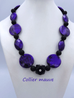 Magnifique collier de couleur bleu foncé avec insertion de perles noire et au centre il y a un dé.