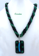 Sa conception a été faite avec des perles noires ainsi que des perles vertes et noires, il est terminé par une pièce de métal argent et des perles noires et vertes. Longueur:54 cm Pendentif: est en forme de rectangle av. fond noir et de petits carrés de vert et un rectangle bleu. 5 cm