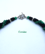 Sa conception a été faite avec des perles noires ainsi que des perles vertes et noires, il est terminé par une pièce de métal argent et des perles noires et vertes. Longueur:54 cm Pendentif: est en forme de rectangle av. fond noir et de petits carrés de vert et un rectangle bleu. 5 cm