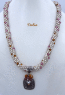 Collier de perles fait avec des perles rocaille en verre clair et insertion de perles or et rose. Pour faire ce collier, des perles rocaille ont été utilisées et terminées par des cônes métal argent ainsi que des perles blanches, rose, et brunes d'une longueur de 57 cm Le pendentif est composé d'une base carrée avec des perles rose et jaune, sa longueur est de 3 cm