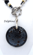 Collier de perles Delphine, il est composé de perles noire avec insertion de perles argent et or le tout est terminé par des embouts de métal argent et une grosse perle noire et une autre plus petite. Il possède un fermoir a bascule qui est très décoratif. Son pendentif est une pièce de céramique noire avec insertion de petits points blanc.Il mesure 61 cm de long est facile à utiliser avec fermoir décoratif argenté. Son pendentif est en céramique il fait 5 cm.