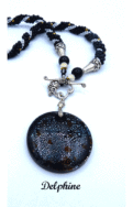 Collier de perles Delphine, il est composé de perles noire avec insertion de perles argent et or le tout est terminé par des embouts de métal argent et une grosse perle noire et une autre plus petite. Il possède un fermoir a bascule qui est très décoratif. Son pendentif est une pièce de céramique noire avec insertion de petits points blanc.Il mesure 61 cm de long est facile à utiliser avec fermoir décoratif argenté. Son pendentif est en céramique il fait 5 cm.