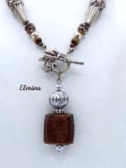 Ce collier est composé de perles brunes avec insertion de perles or.Il est terminé par une cone argent et des petites perles brunes et or. Il mesure: 59cm son pendentif est carré de couleur brune et or et il mesure 6cm.. Le fermoir est a bascule en argent
