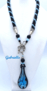 Ce collier de perles est de création et conception uniques. Il mesure 56 cm le pendentif de verre 6 cm Le fermoir est idéal pour les personnes qui ont des douleurs aux mains. Cette création a été fait avec des perles noires et insertion de perles bleues. Un certificat confirme son unicité. Beau collier de perles viendra compléter n’importe quelle tenue, conviens pour le bureau et pour la soirée. C’est une excellente idée cadeau pour anniversaire ou toute autre occasion. Il mesure 56 cm le pendentif de verre 6 cm