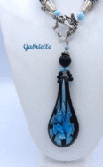 Ce collier de perles est de création et conception uniques. Il mesure 56 cm le pendentif de verre 6 cm Le fermoir est idéal pour les personnes qui ont des douleurs aux mains. Cette création a été fait avec des perles noires et insertion de perles bleues. Un certificat confirme son unicité. Beau collier de perles viendra compléter n’importe quelle tenue, conviens pour le bureau et pour la soirée. C’est une excellente idée cadeau pour anniversaire ou toute autre occasion. Il mesure 56 cm le pendentif de verre 6 cm