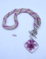 Ce collier  a été créé avec des perles de verre et insertion de perles rose. Ce collier est terminé avec des embouts de métal argent et une grosse perle transparente et une petite perle rose. Son fermoir à bascule est décoratif  Le pendentif mesure 4 cm 1/2 en forme de carré en verre transparent et une fleur rose a l'intérieur. L’air grand et élégant !