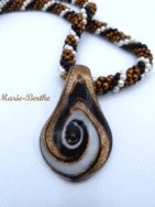 Sa création est unique et fabriquée avec des perles ayant les couleurs bronze avec insertion de perles blanches et noires.