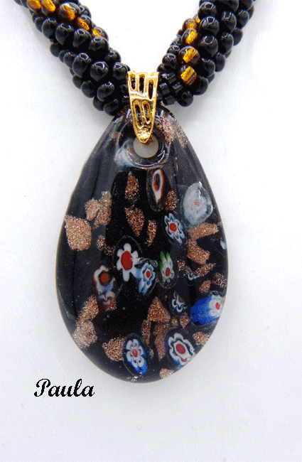 Ce collier de perles de verre de couleur noire avec insertion de perles or. Il est terminé par deux petits cones or une perle noire Il mesure 57 centimètres Son pendentif fait 6 centimètres.