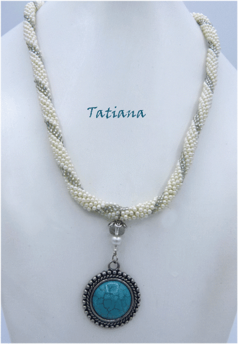Collier de perles Tatiana fait avec des perles blanches et insertion de perles vertes très pale le tout fini avec un fermoir a bascule et au centre en avant il a un magnifique pendentif de couleur turquoise. Il mesure 52 centimètres et son pendentif est de 4 centimètres.