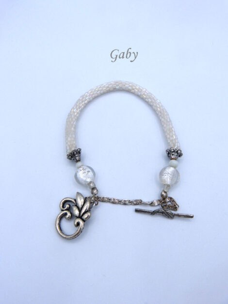 Bracelet de perles Gaby il est composé de perles de verre blanc et transparent il est terminé par des embouts de métal argent et une petite perle blanche et une grosse perle transparente. Il possède un fermoir a bascule avec une petite chaîne de sécurité. Il mesure 21 à 25cm.