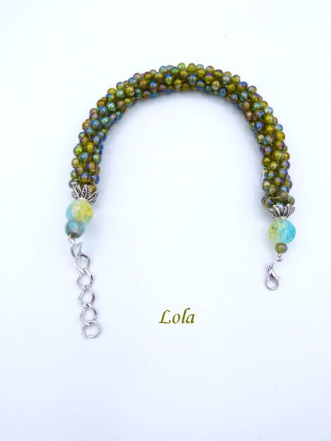 Bracelet de perles de verre miroitant avec du vert, bleu, et or sont fabriqués à la main. Il est terminé par un embout de métal et une grosse perle avec les mêmes couleurs que le collier et un fermoir a pince de homard, le tout terminé par une chaîne afin d'assurer un bon réglage.