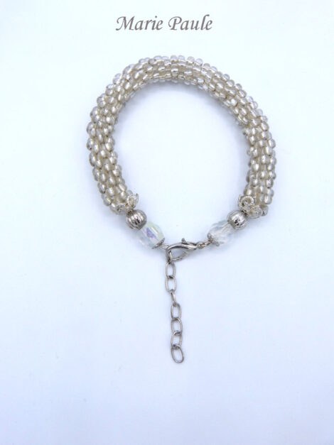Bracelet de perles Marie Paule est composé de perles de verre transparent avec une finition en métal argent et une autre perle argent et une grosse perle en verre transparent. Il possède un fermoir pince de homard et une chaîne pour un ajustement. Il mesure 21 à 25cm.