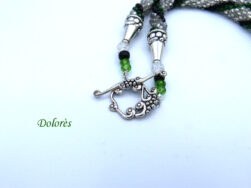 En diagonale technique tubulaire avec crochet, les perles sont de couleur transparente avec insertion de perles vertes et noires .avec un fermoir a bascule argent Cette pièce unique mesure 56 cm. Son pendentif : 4 cm