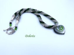 Collier de perles Dolorès est fait avec des perles de verre transparent et insertion de perles noire et verte.Le collier est terminé par des embouts de métal et une perle de verre transparente et une petite perle noire et deux perles vertes. Le fermoir a basculé en argent représentant des petits raisins est facile à attacher et décoratif.Cette pièce unique mesure 56 cm. Sont pendentif est un coeur en verre il y a du verre transparent du vert et du noire.il mesure 4 cm