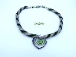 En diagonale technique tubulaire avec crochet, les perles sont de couleur transparente avec insertion de perles vertes et noires .avec un fermoir a bascule argent Cette pièce unique mesure 56 cm. Son pendentif : 4 cm