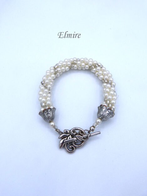 Bracelet de perles de verre Elmire il se compose de perles blanches avec insertion de perles transparentes le tout est terminé par des embouts de métal argent et une petite perle blanche et une perle transparente.. Il se termine avec un fermoir décoratif a bascule. Ce bracelet mesure 20 cm