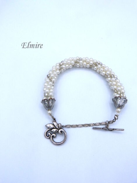Bracelet de perles de verre Elmire il se compose de perles blanches avec insertion de perles transparentes le tout est terminé par des embouts de métal argent et une petite perle blanche et une perle transparente.. Il se termine avec un fermoir décoratif a bascule. Ce bracelet mesure 20 cm