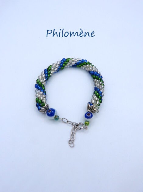 Ce bracelet de perles est doté d’un agencement des perles de couleur de verre transparent, de bleue et de vert. Il est terminé par un embout de métal et une grosse perle en forme d'œil bleu et une plus petite perle verte. Il possède un fermoir pince de homard. Ce bracelet de perles de verre mesure: 19 cm, pouvant avec chaîne avoir une longueur de 24 cm avec une chaîne pour un ajustement..