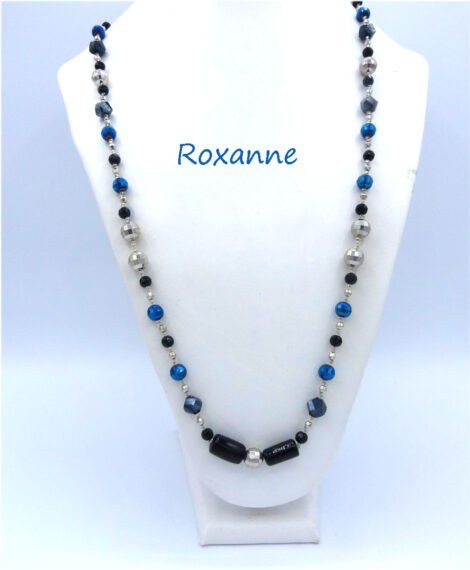 collier de perles Roxanne. Il est composé dans le centre de deux perles noires rectangulaires et par la suite de belles perles bleues et de perles noire et argent. Fermoir qui est aussi décoratif. Dimension: 78 cm.
