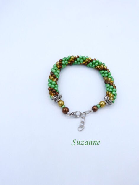 Ce bracelet de perles Marie-Suzanne est fait de perles tchèques de haute qualité. Ce bracelet est composé de perles vertes avec insertion de perles or et brune. Il est terminé par des embouts de métal et une grosse perle or une plus petite verte et une autre brune. Son fermoir est une pince de homard argent avec une chaîne pour un bon ajustement. Ce bracelet mesure de 20 à 21 cm.