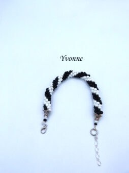 Il est composé de perles noires et blanches. Il est terminé par un embout de métal argent ensuite deux petites perles et un fermoir pince de homard. Il a une petite chaîne afin de faire un bon ajustement. Longueur:21 à 25 cm