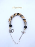 Ce bracelet de perles de verre Berthe est fait de perles tchèques de haute qualité. Ce bracelet de perles  se compose de perles or avec insertion de perles blanches et noires, il est terminé par un embout de métal et une grosse perle noire et de petites perles or et blanc. Il possède un fermoir à bascule argent avec une chaîne de sécurité. Il mesure:19 à 23 cm