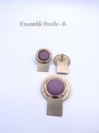 Broche mode entièrement faite à la main. Cette dernière est un cercle or avec une pièce rectangulaire or le tout terminée par une perle lilas cette broche mesure 5 cm x 3.5 cm Boucles d’oreilles pour oreilles percées. Elles sont faites comme la broche. Elles mesurent 4 x 2cm.