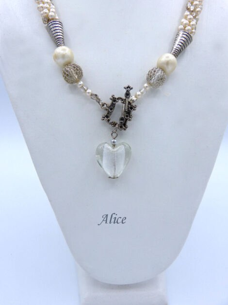 Collier de perles blanches fait au crochet avec insertion de perles transparente en verre le tout terminé par un fermoir à bascule argent et le pendentif est un gros coeur en verre transparent.