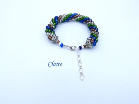Bracelet de perles de verre fait au crochet avec des perles verte et insertion de perles bleu et brunes, le tout terminé par un fermoir à pince de homard.