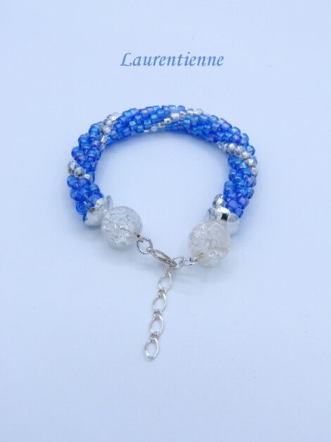 Bracelet de perles de verre il est dans dans les couleurs de bleu avec insertion de perles argent. Sa finition est avec une grosse perle en verre transparent et un fermoir homard. Ce bracelet est fait de perles tchèques. Il mesure:18 à 21 cm