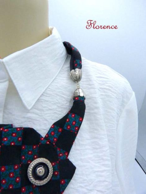 collier fait avec une cravate de couleur noire avec un peu de bleue et des petits points rouges a aussi trois boutons.