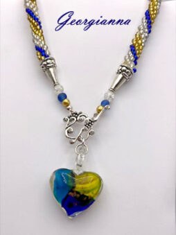Ce collier est accompagné de son certificat d’authenticité.
Créé à partir de perles de rocaille dorées, argentées et bleues, il mesure 55 cm et se termine par un fermoir pratique, idéal pour ceux qui peinent à attacher leurs bijoux.
