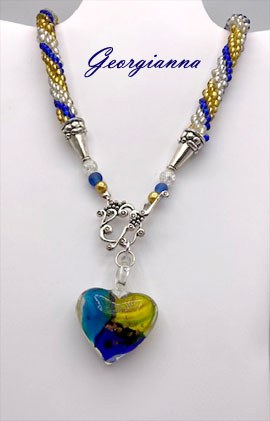 Ce collier est accompagné de son certificat d’authenticité. Créé à partir de perles de rocaille dorées, argentées et bleues, il mesure 55 cm et se termine par un fermoir pratique, idéal pour ceux qui peinent à attacher leurs bijoux.