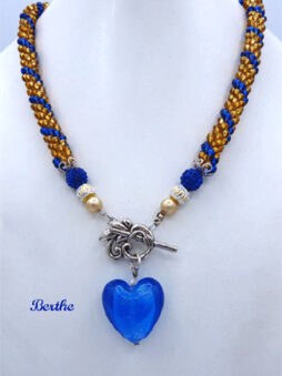 collier de perles brunes avec insertion de perles bleues le tout terminé avec un fermoir a bascule et un magnifique coeur bleu