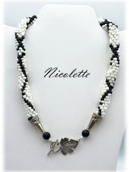 Découvrez l’élégance intemporelle avec ce magnifique collier de perles fait main. Unique en son genre, ce bijou est conçu pour traverser les époques. Il mettra en valeur votre visage avec grâce. Composé de perles blanches et rehaussé par des perles noires, chaque pièce est assemblée avec amour. La qualité supérieure est notre engagement. Le fermoir, pensé pour le confort des mains douloureuses, ajoute à son charme.