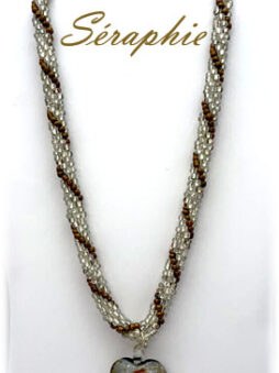 Ce magnifique collier est entièrement crocheté à la main avec des perles tchèques de couleur claire et agrémenté de perles de bronze. Le fermoir est orné de caps argentées et se ferme avec un fermoir à bascule, offrant une grande facilité d’utilisation. Le collier mesure 53 cm de longueur totale (20 3/4 pouces) et 3 1/2 cm de largeur (1 1/4 pouce), ce qui en fait un accessoire à la fois élégant et polyvalent. Au centre de ce collier, vous trouverez une pièce de verre en forme de cœur, qui apporte une touche de romantisme et de sophistication. Ce collier est non seulement un choix de mode exceptionnel, mais il peut également être un cadeau magnifique pour quelqu’un de spécial.