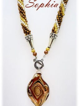 Ce collier de perles unique est un héritage en puissance, promis à traverser les époques. Il magnifie le visage avec grâce et raffinement. Chaque pièce est façonnée à la main, intégrant des perles transparentes agrémentées de touches d’or et de bronze. Les perles de rocaille sélectionnées confèrent à l’œuvre une finesse inégalée. Confectionné avec soin dans mon atelier de Laval, je veille à ce que chaque perle soit parfaitement positionnée. Le fermoir, pensé pour le confort, convient idéalement aux personnes souffrant de douleurs manuelles. Accompagné de son certificat d’authenticité, ce collier mesure 50 cm avec un pendentif de 6 cm et un diamètre de 3 1/2 cm
