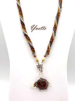 Imaginez un pendentif en verre en forme d’éléphant, symbole de chance. Conçu avec des perles dorées, blanches et grises, il émane une élégance subtile. Chaque collier est accompagné d’un certificat d’authenticité. Le fermoir décoratif est une aubaine pour ceux souffrant de douleurs aux mains. D’une longueur de 52 cm, le pendentif mesure 4 cm x 5 cm.